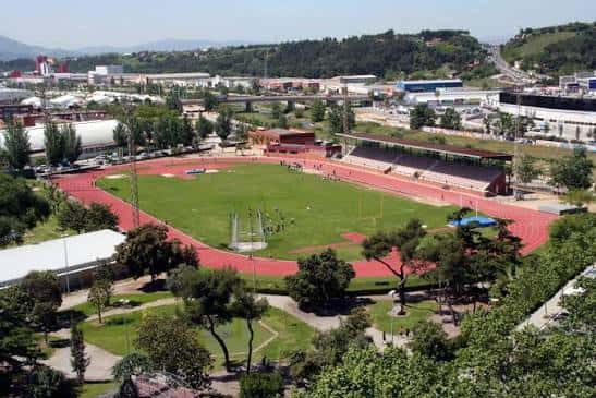 Vista aérea panorámica de las pistas municipales con pista de atletismo roja y campo central verde