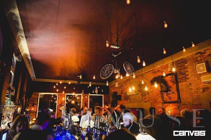 Interior del bar con ambiente festivo y decoración de luces colgantes