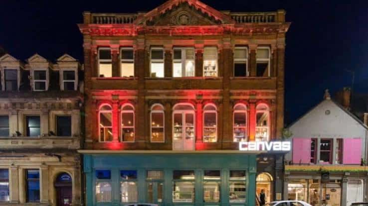 Fachada exterior del local Canvas en Bournemouth iluminado por la noche