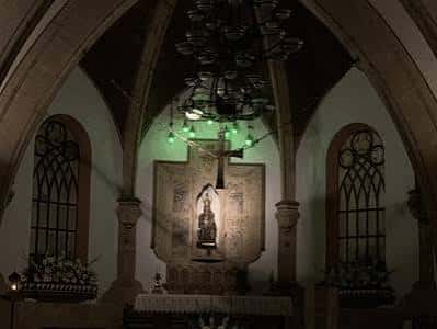 Interior del altar principal con crucifijo y decoración litúrgica