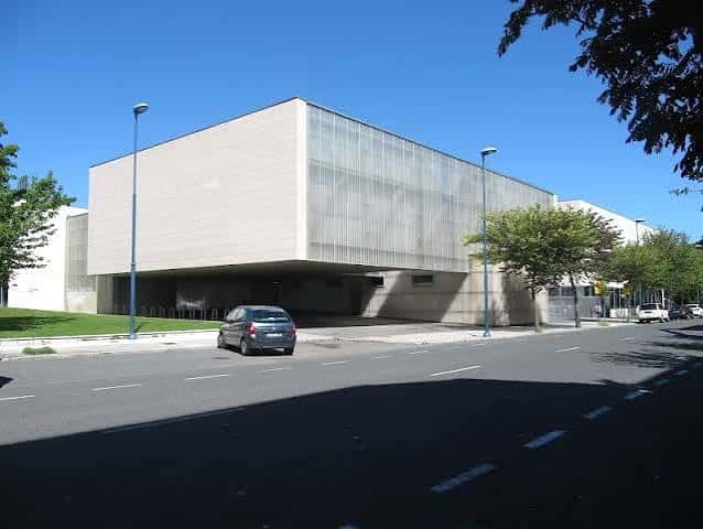 Vista exterior del Polideportivo San Andrés mostrando su fachada moderna de hormigón y cristal