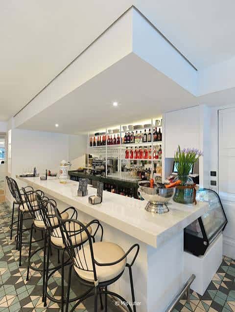 Bar moderno con estantería de botellas y taburetes altos