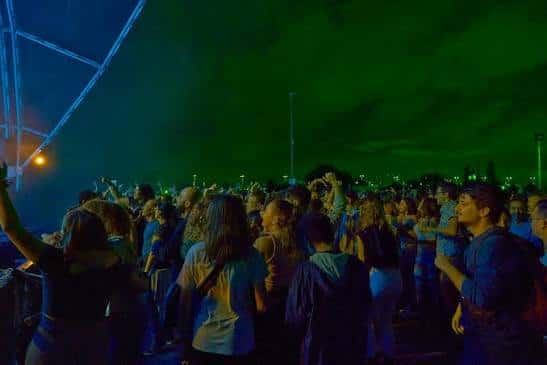 Vista de la multitud en el concierto nocturno bajo luces verdes