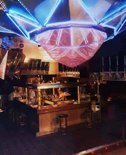 Bar interior de La Boite con iluminación neón y decoración moderna