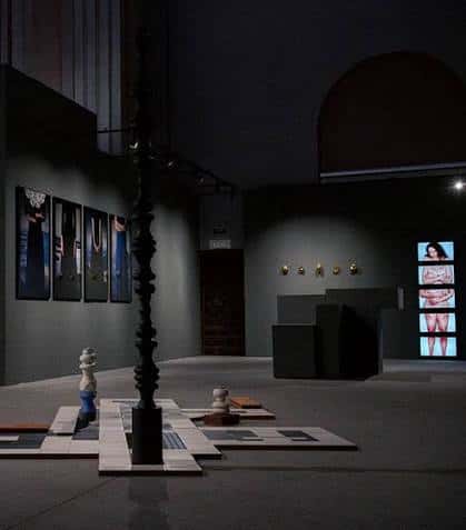 Interior de la sala mostrando una instalación artística central y obras en las paredes