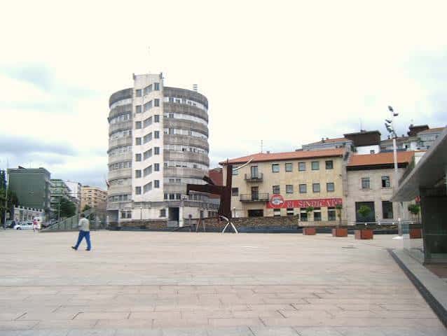Plaza de La Llama mostrando el edificio cilíndrico y la escultura metálica central