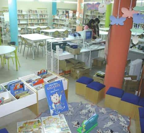 Interior de la biblioteca mostrando el área infantil con estanterías y mesas