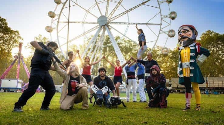 Grupo de personas posando frente a una noria con un gigante de Girona