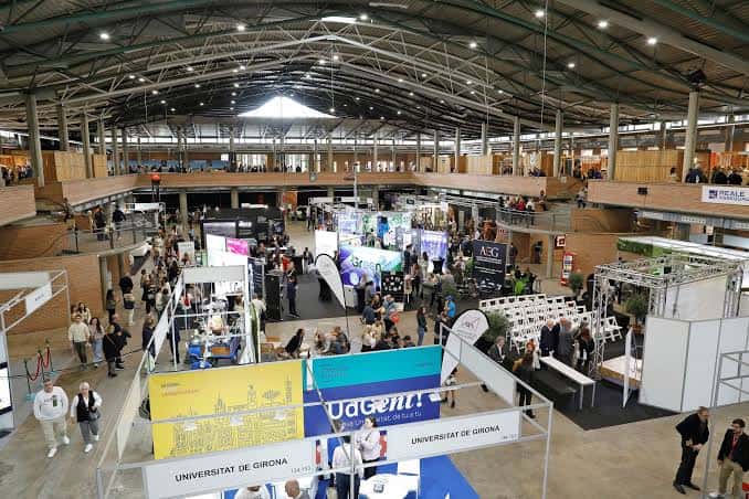 Espacio interior del centro de ferias con exposiciones y visitantes