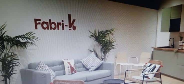 Área de descanso en Fabri-K con sofá, plantas y decoración minimalista