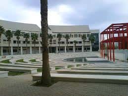 Plaza central del campus con palmeras y estructura roja decorativa