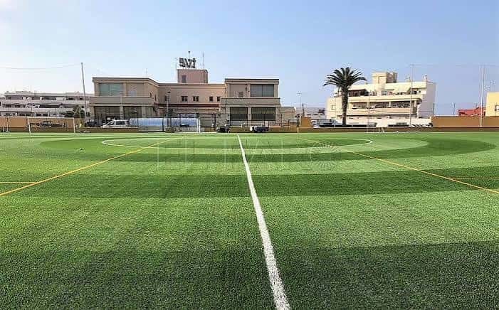 Vista general del campo de fútbol Emilio Cózar con césped artificial y gradas al fondo