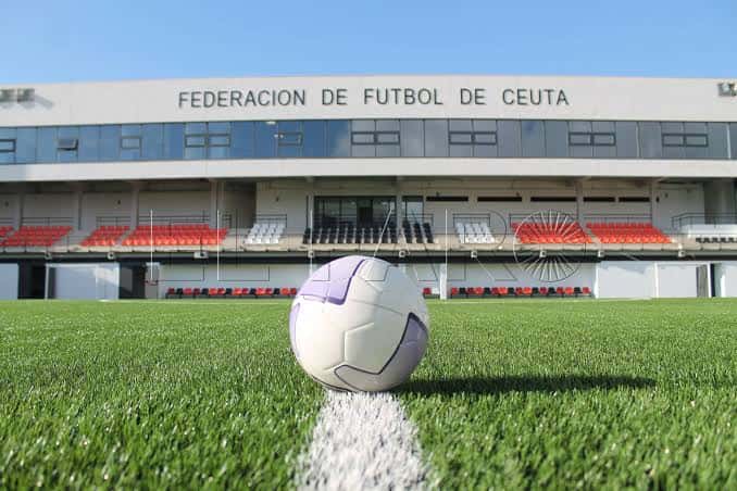 Primer plano de balón de fútbol sobre la línea central frente a las gradas vacías