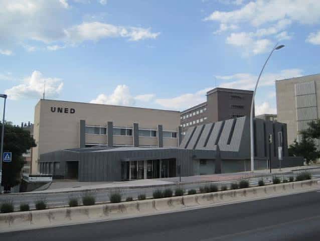 Panorámica del edificio UNED desde la calle, mostrando su arquitectura contemporánea y entorno urbano