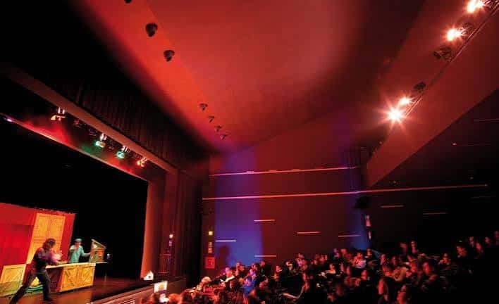 Espectáculo en vivo con iluminación roja y público sentado