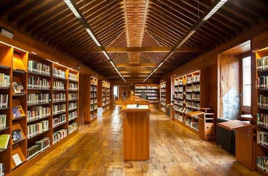 Interior de la sala principal con estanterías de madera y techo abovedado