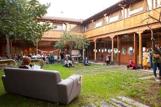 Patio interior con zona verde y personas disfrutando del espacio