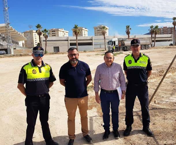 Grupo de personas en el lugar del parque infantil durante su construcción o inauguración