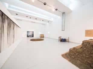 Sala de exposiciones moderna con instalaciones artísticas en el suelo