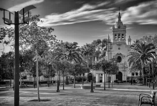 Plaza arbolada frente a la iglesia en blanco y negro