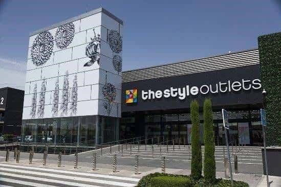 Fachada exterior del centro comercial The Style Outlets con su logotipo distintivo