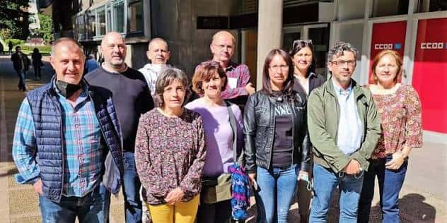Reunión de miembros en el exterior del edificio sindical con logotipo visible