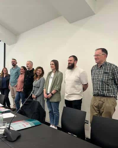Presentación o rueda de prensa en sala de reuniones con micrófono y mesa