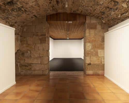 Vista del interior de la sala principal con bóvedas de piedra y suelo de baldosas