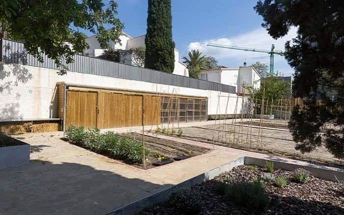 Área de trabajo del huerto con parcelas ordenadas y estructura de madera