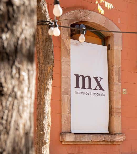 Detalle de la entrada lateral con cartel blanco y luces decorativas