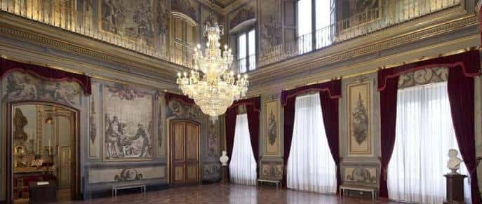 Salón elegante del Palau Moja con cortinas rojas y detalles ornamentales