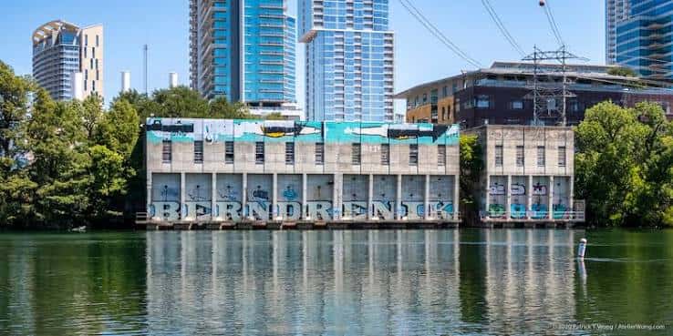Vista panorámica del edificio de la planta de captación de agua en el lago Lady Bird con rascacielos al fondo
