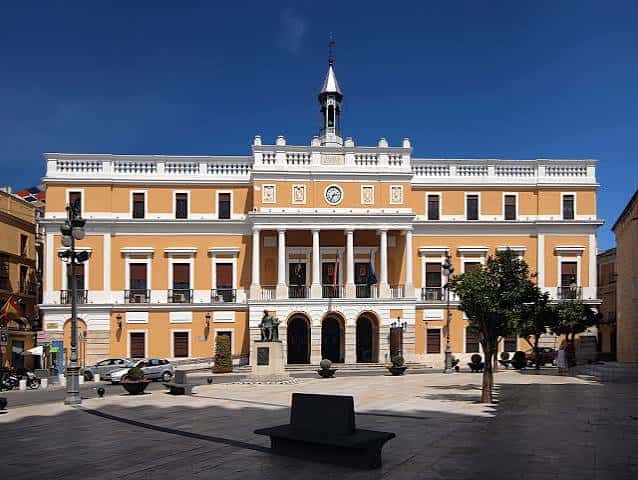 Vista lateral de la fachada barroca de la Universidad de Valladolid bajo cielo azul