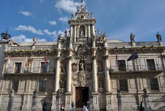 Entrada monumental de la Universidad de Valladolid con banderas y detalles arquitectónicos