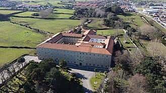 Vista aérea del Monasterio de Monte Corbán rodeado de campos verdes