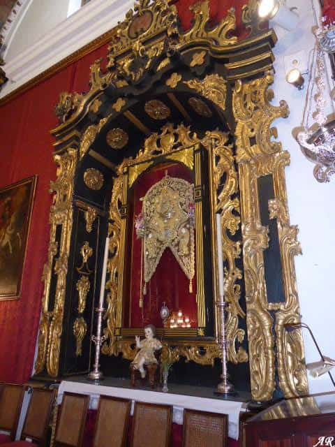Altar interior con retablo dorado y imagen religiosa enmarcada