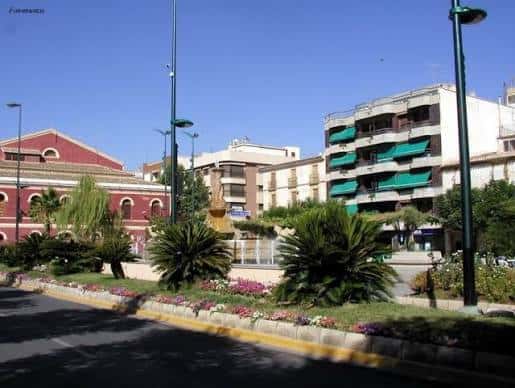 Vista panorámica de la plaza con jardines y arquitectura urbana bajo cielo despejado