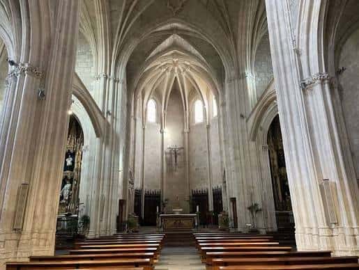 Interior de la nave principal con bóvedas góticas y altares laterales