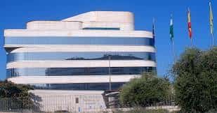 Fachada moderna de la Diputación Provincial de Granada con banderas al viento