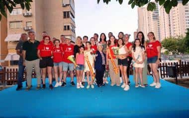 Grupo de personas posando en una alfombra azul al aire libre