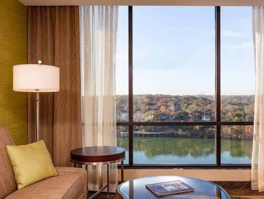 Sala de estar con ventana panorámica que ofrece vista al lago y árboles otoñales