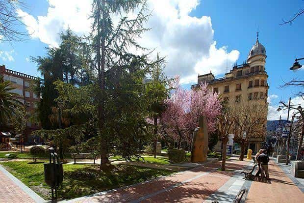 Vista panorámica del Parque El Parterre con árboles frondosos y edificios históricos al fondo
