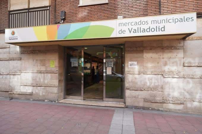 Acceso al edificio de los Mercados Municipales de Valladolid con señalización institucional