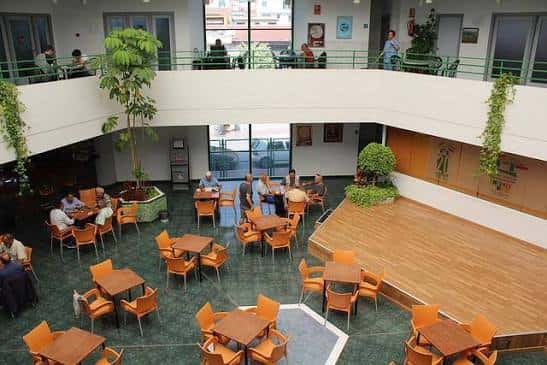 Interior del Centro Social José Llorca Linares con zona de cafetería y escenario