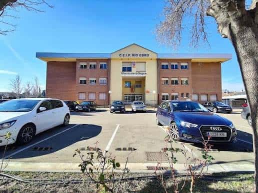 Vista exterior del CEIP Río Ebro con fachada de ladrillo y aparcamiento