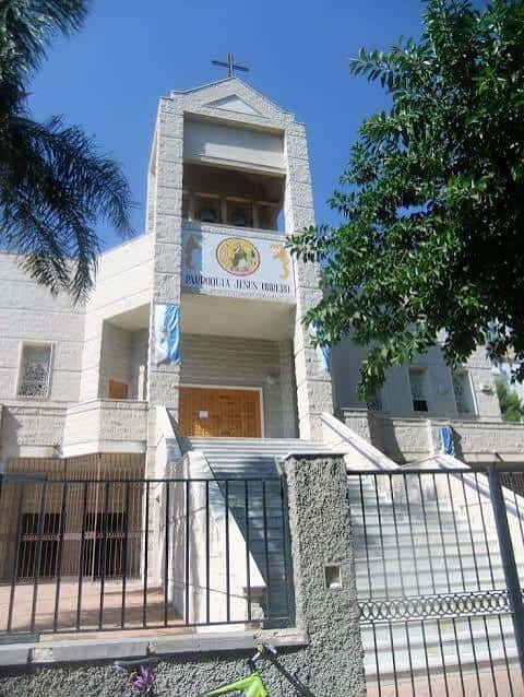 Fachada principal de la Parroquia de Jesús Obrero en Málaga con cruz y escudo