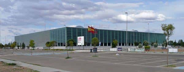 Vista panorámica del edificio Ifeza con banderas españolas y aparcamiento frente a la entrada