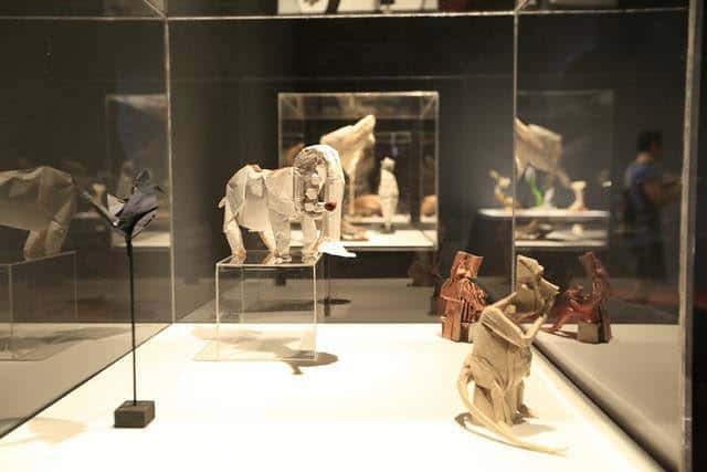 Vitrina con diversas esculturas de origami incluyendo animales y figuras humanas