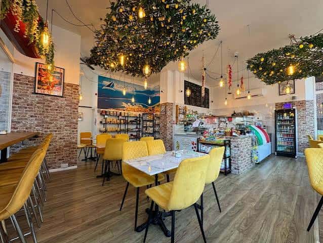 Interior del restaurante Da Nunzio con decoración italiana y mesas amarillas