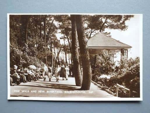 Vista histórica del Pine Walk Bandstand rodeado de árboles y visitantes